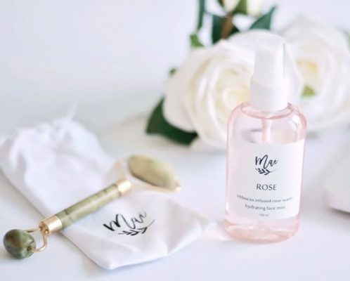 Jade roller next to hibiscus infused face mist